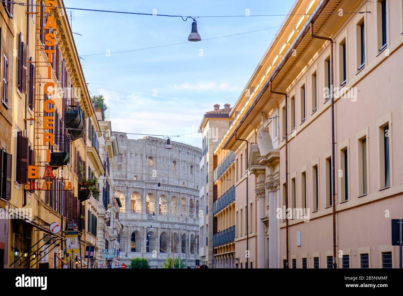 Edifici dell'antica Roma, vista sulla strada del Colosseo Romano circondato da edifici residenziali e commerciali, Roma, Italia. Foto Stock