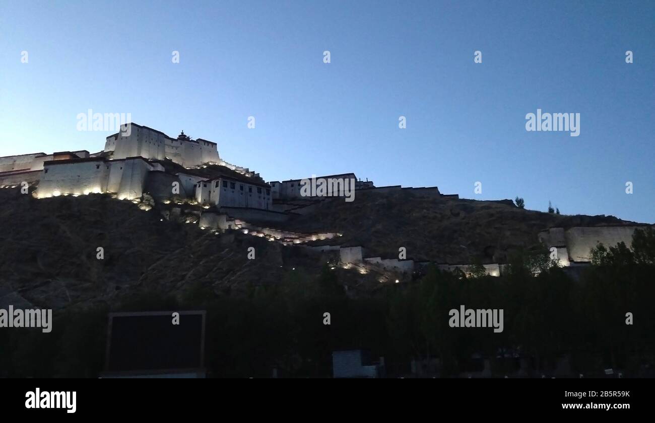 Crepuscolo e illuminazione elettrica a Gyantse Dzong, una fortezza arroccata sull'omonima città del Tibet Foto Stock