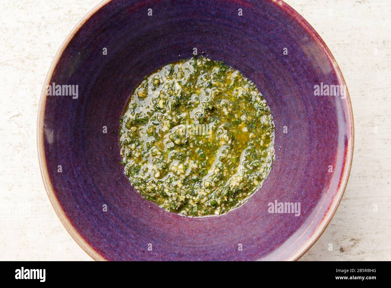 Pesto di basilico in ciotola viola dall'alto sulla Superficie bianca Foto  stock - Alamy