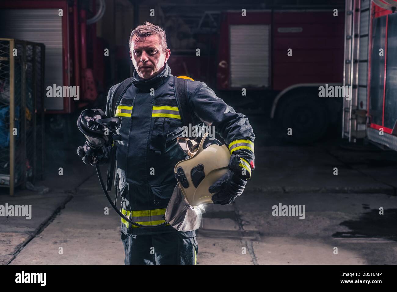 Vigile del fuoco con uniforme protettivo indossando maschere di ossigeno Foto Stock