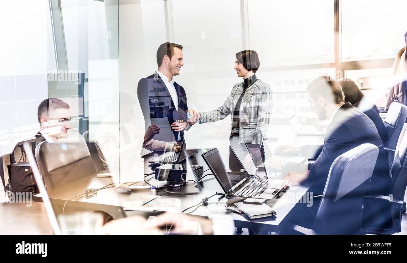 Persone aziendali sicure che si scuotono le mani in un ufficio aziendale più moder. Foto Stock