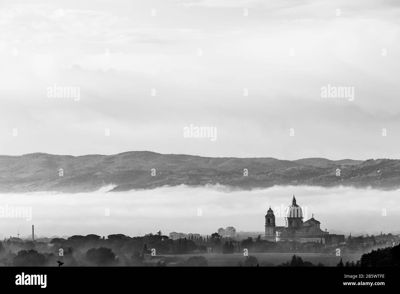 Vista surreale della chiesa papale di Santa Maria degli Angeli (Assisi) sullo sfondo della nebbia Foto Stock
