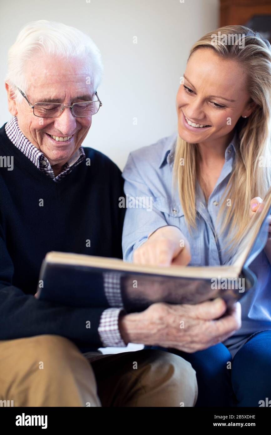 Nonno Guardando Album di foto con il nipote per adulti Foto Stock