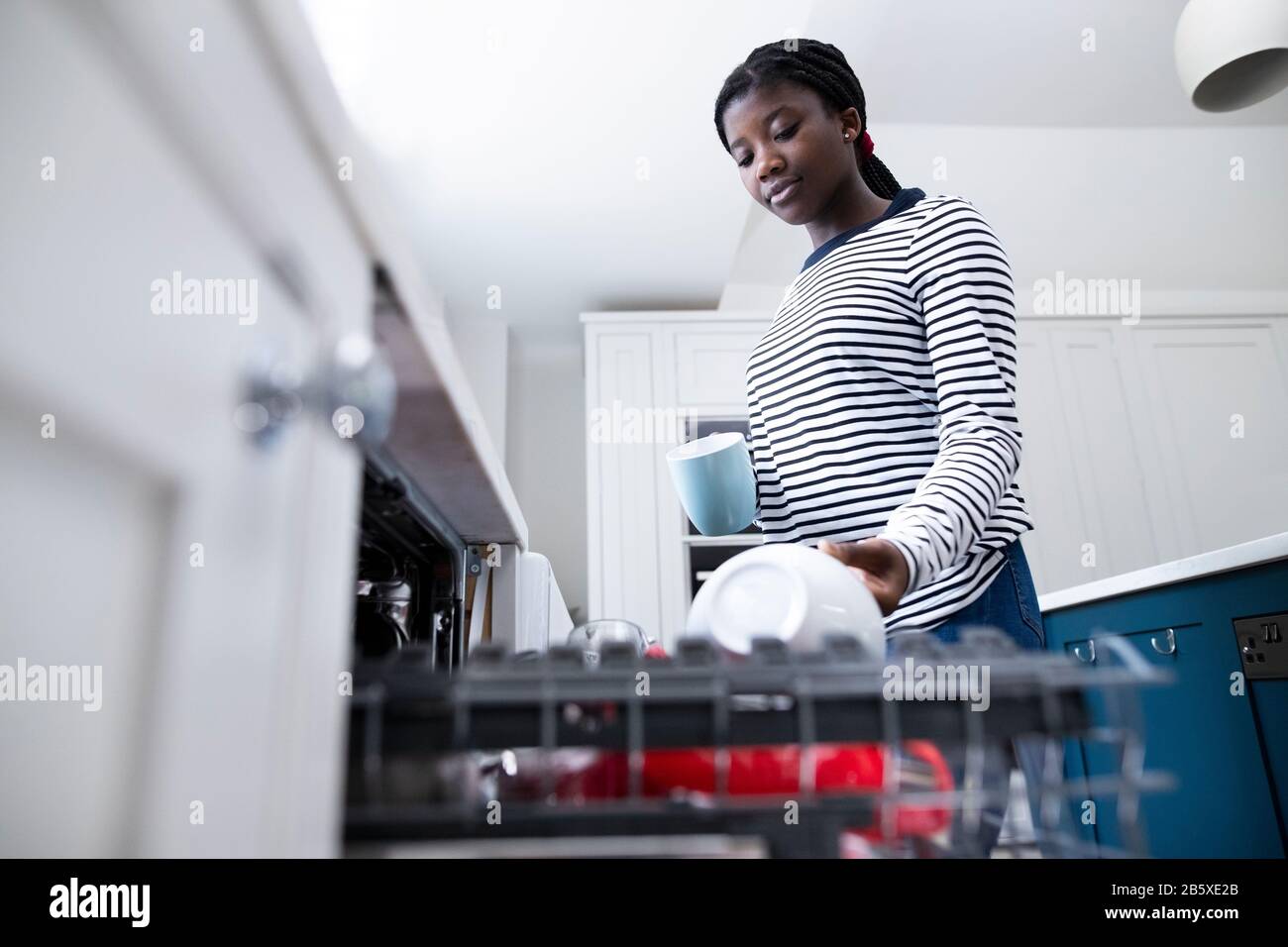 Teenage Girl Boy Aiutare Con I Chores A Casa Da Stacking Stoviglie In Lavastoviglie Foto Stock