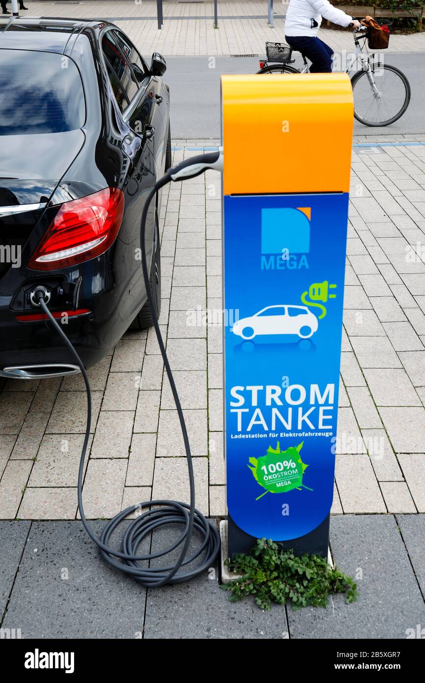 Monheim am Rhein, Renania Settentrionale-Vestfalia, Germania - un'auto elettrica refuels eco-potenza in una stazione di rifornimento elettrico su un parcheggio pubblico. Monheim Foto Stock