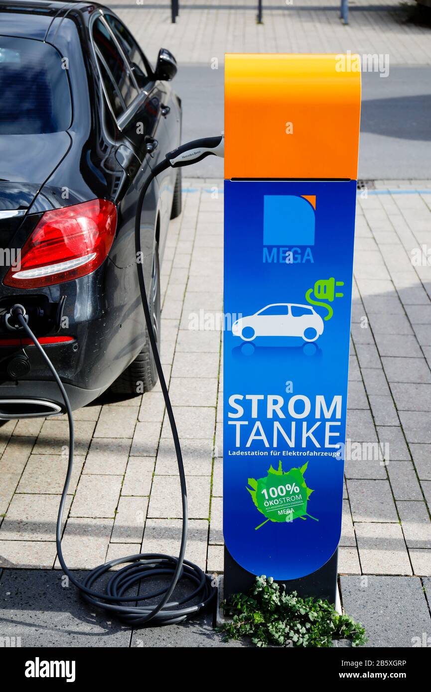 Monheim am Rhein, Renania Settentrionale-Vestfalia, Germania - un'auto elettrica refuels eco-potenza in una stazione di rifornimento elettrico su un parcheggio pubblico. Monheim Foto Stock