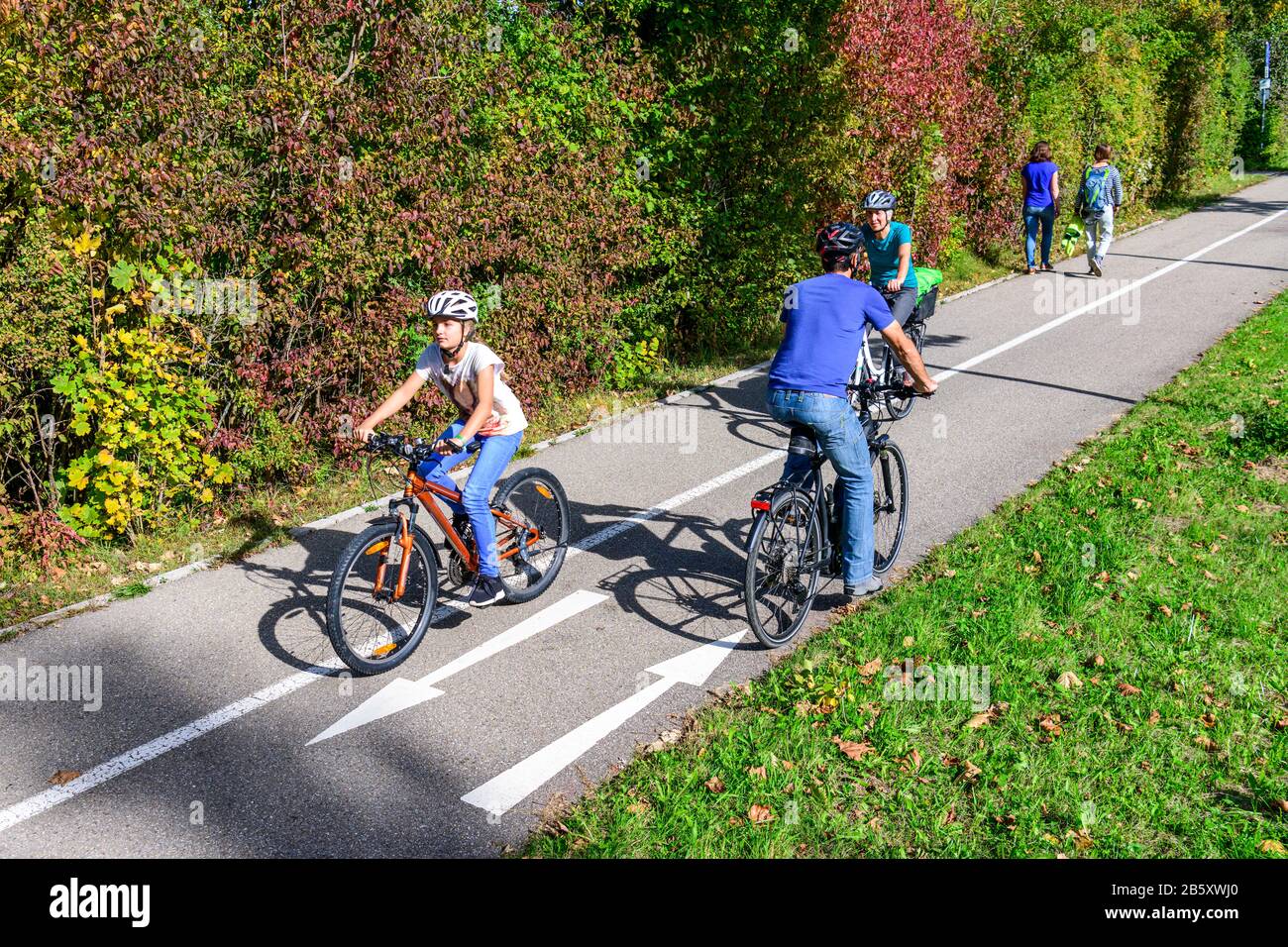Ciclisti e pedoni che viaggiano insieme su un percorso ciclabile e pedonale Foto Stock