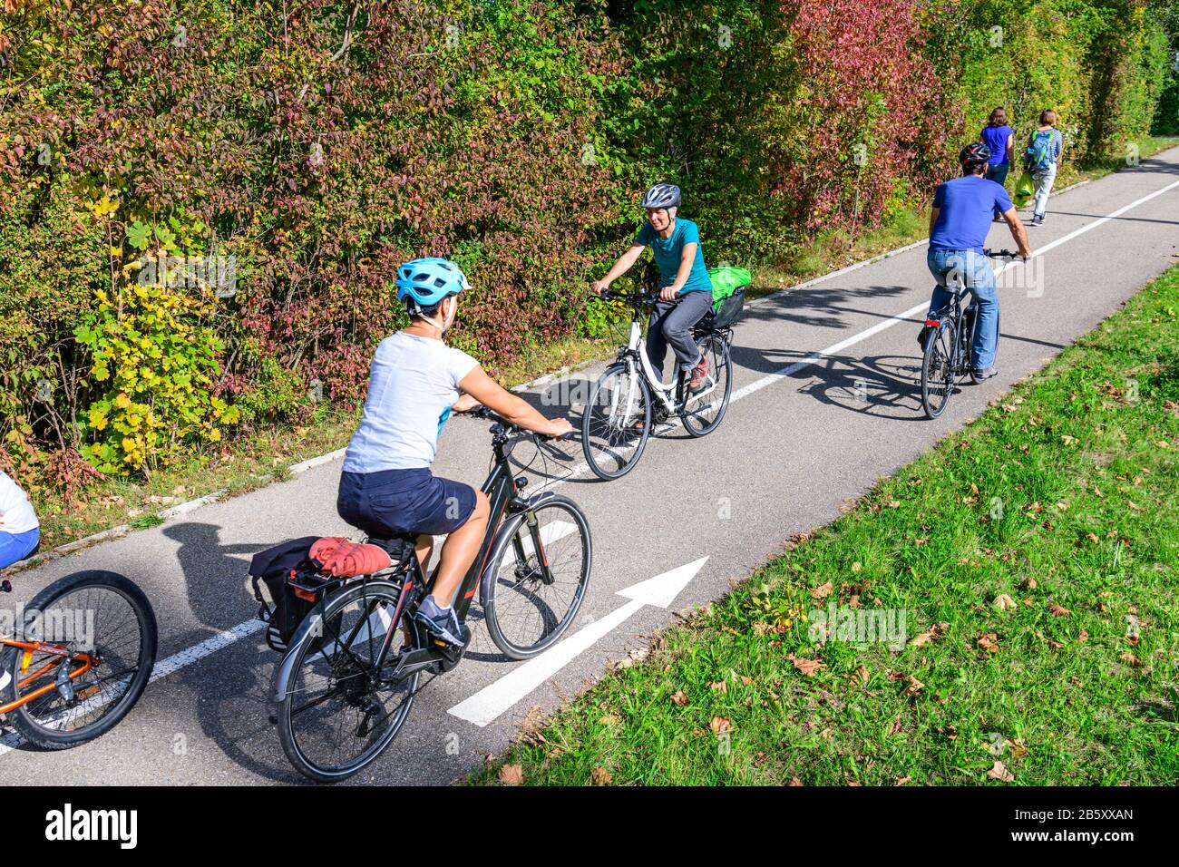 Ciclisti e pedoni che viaggiano insieme su un percorso ciclabile e pedonale Foto Stock
