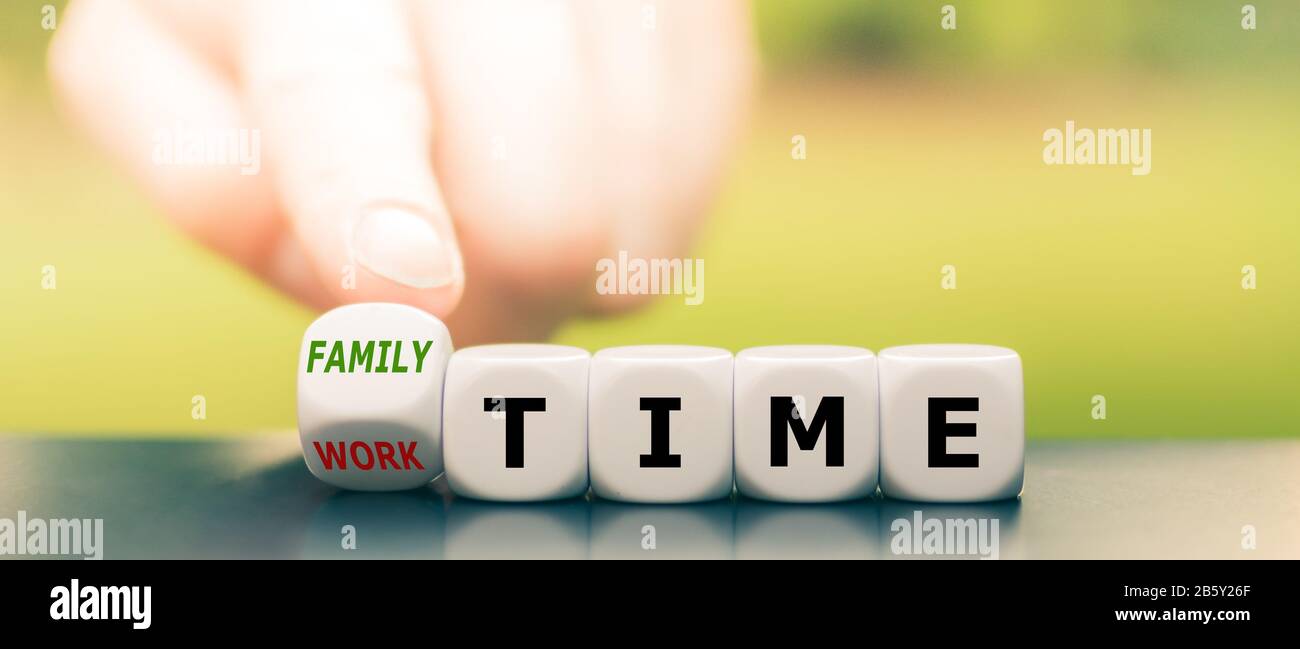 Mano gira i dadi e cambia l'espressione "tempo di lavoro" in "tempo di famiglia". Foto Stock