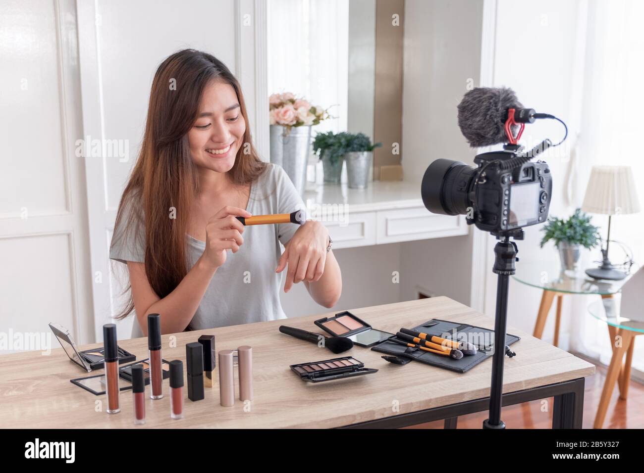 Asian giovane femmina blogger vlog di registrazione video con cosmetici per il trucco a casa consulente online su social media concetto.live streaming viral Foto Stock