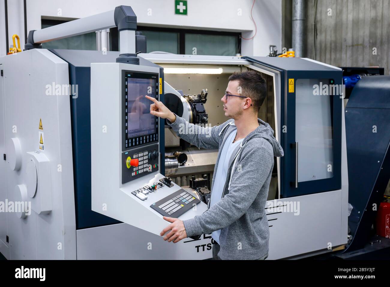 Remscheid, Renania Settentrionale-Vestfalia, Germania - apprendista nelle professioni del metallo, qui in una macchina utensile CNC, centro di formazione professionale del Remscheid Foto Stock