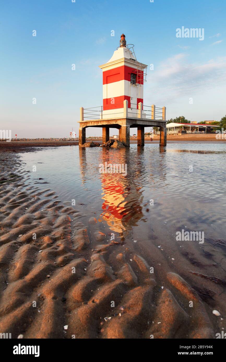 Beach with lighthouse in Italy resort Lignano at sunrise Foto Stock