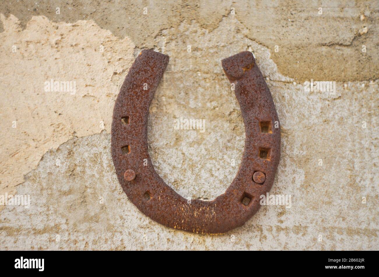 vecchio ferro di cavallo in acciaio su sfondo vintage parete Foto Stock