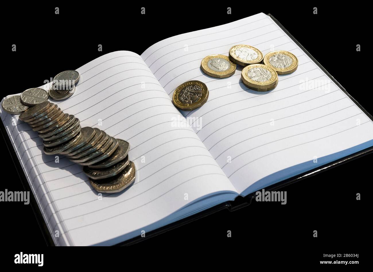 monete su taccuino con concetto di background.money nero Foto Stock