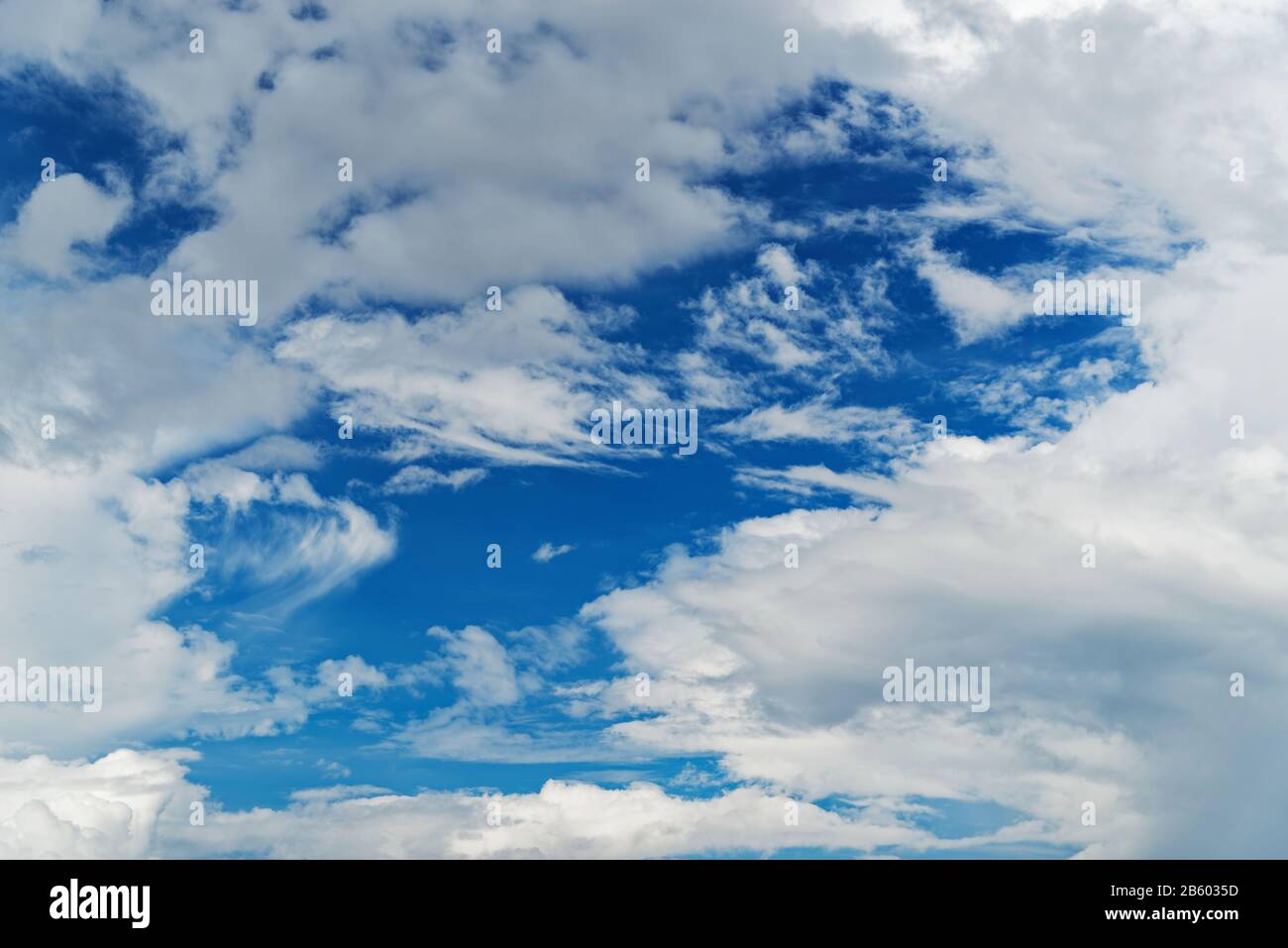 Vista ad angolo basso dello sfondo blu del cielo con nubi minuscole Foto Stock