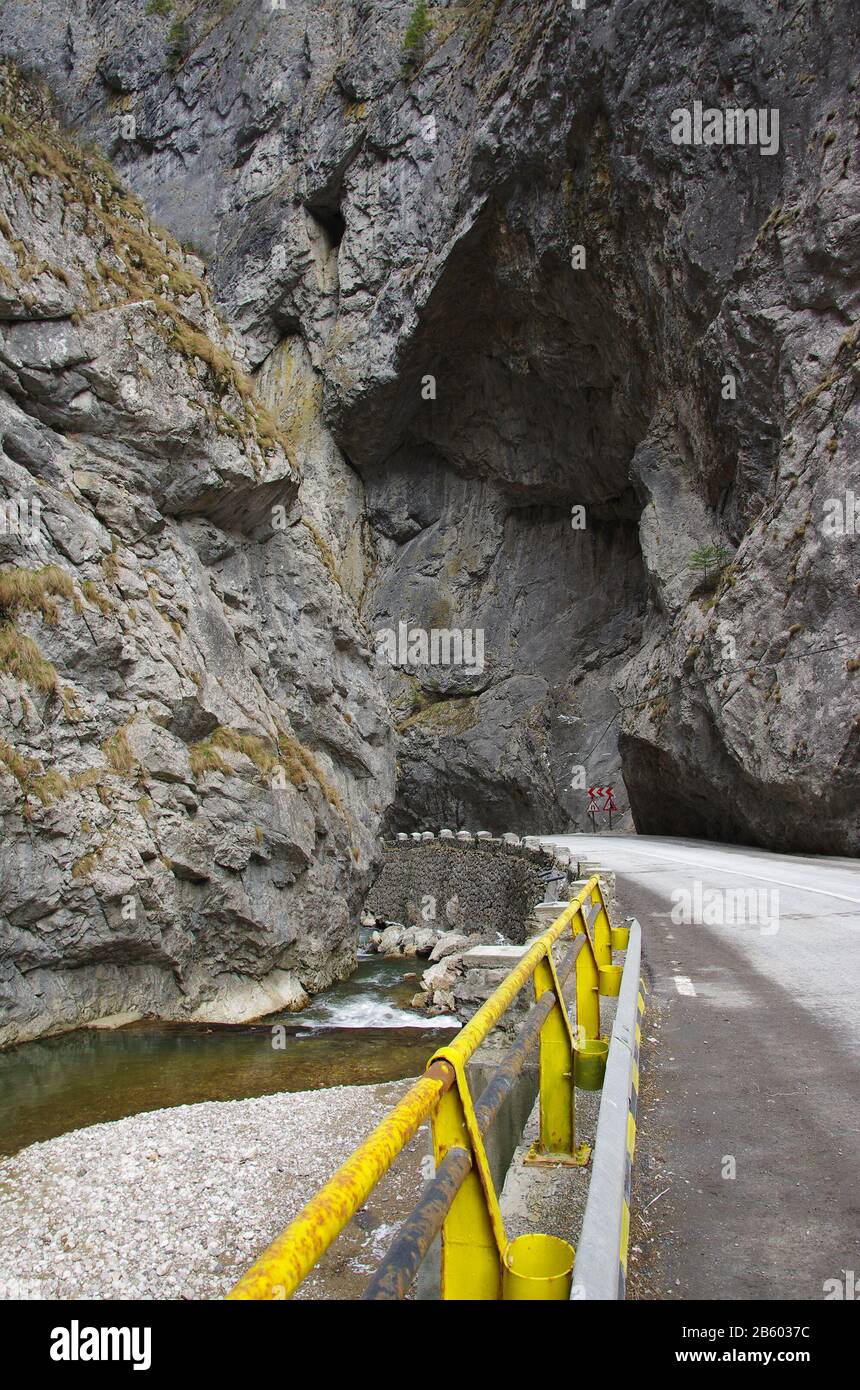 strada che conduce sotto le rocce nelle zone di montagna Foto Stock