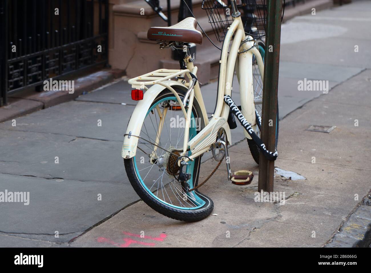 Una bicicletta con una ruota rotta, cerchio piegato 'taco' incatenato ad un palo di segno a New York, NY. Foto Stock
