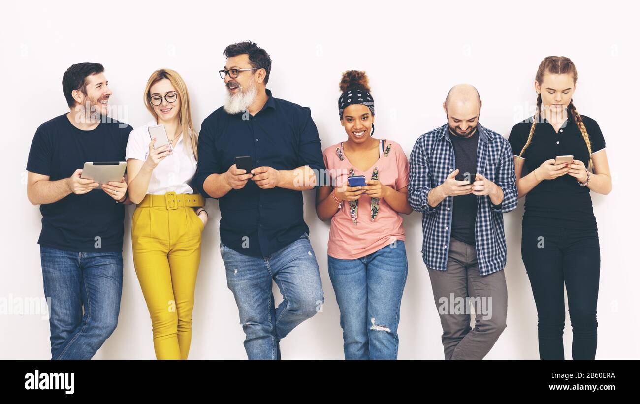 Gruppo multiculturale di amici addicted ai telefoni cellulari intelligenti – concetto di diversità con persone multirazziali che si divertono Foto Stock