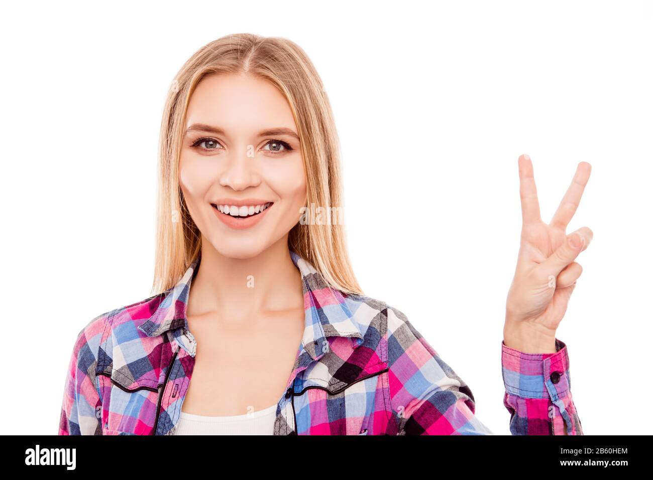 Bella giovane donna con il sorriso beaming che mostra v-sign Foto Stock