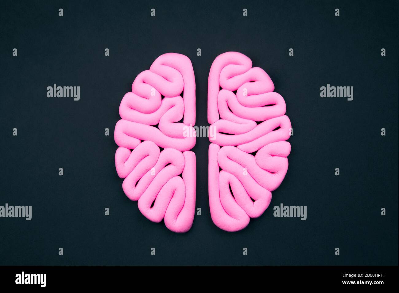 Cervello umano rosa su sfondo nero, piatto. Concetto di intelligenza. Emisferi mockup, layout. Foto Stock
