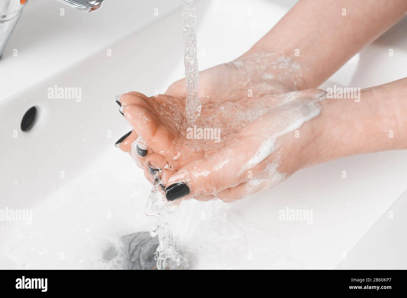 Tecniche efficaci di lavaggio a mano: Donna risciacquare la mano con acqua. Il lavaggio delle mani è molto importante per evitare il rischio di contagio da coronavirus e bact Foto Stock