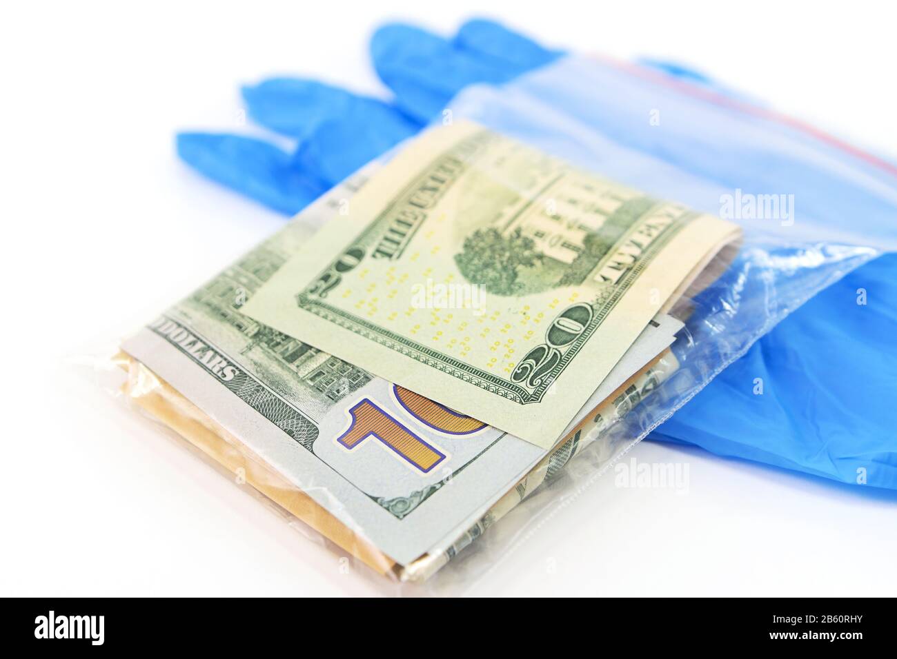Sacchetto di plastica trasparente con denaro che è una fonte di infezione e guanti medici blu Foto Stock