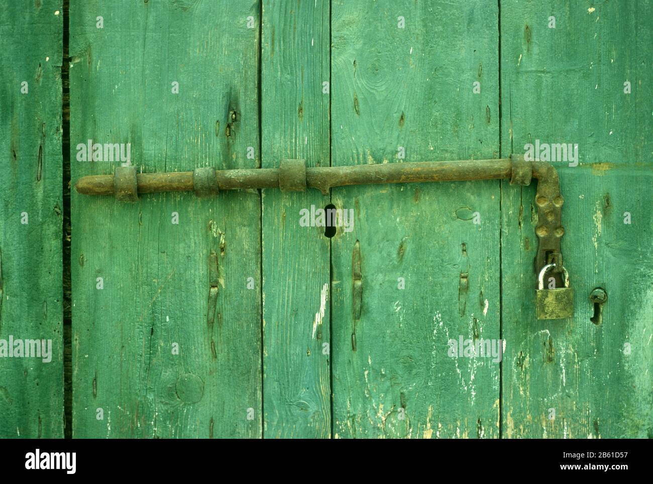 Accessori fatti a mano su una vecchia porta in legno, verniciata, verde a Metsovo, Ioannina, Epiro, Grecia Foto Stock
