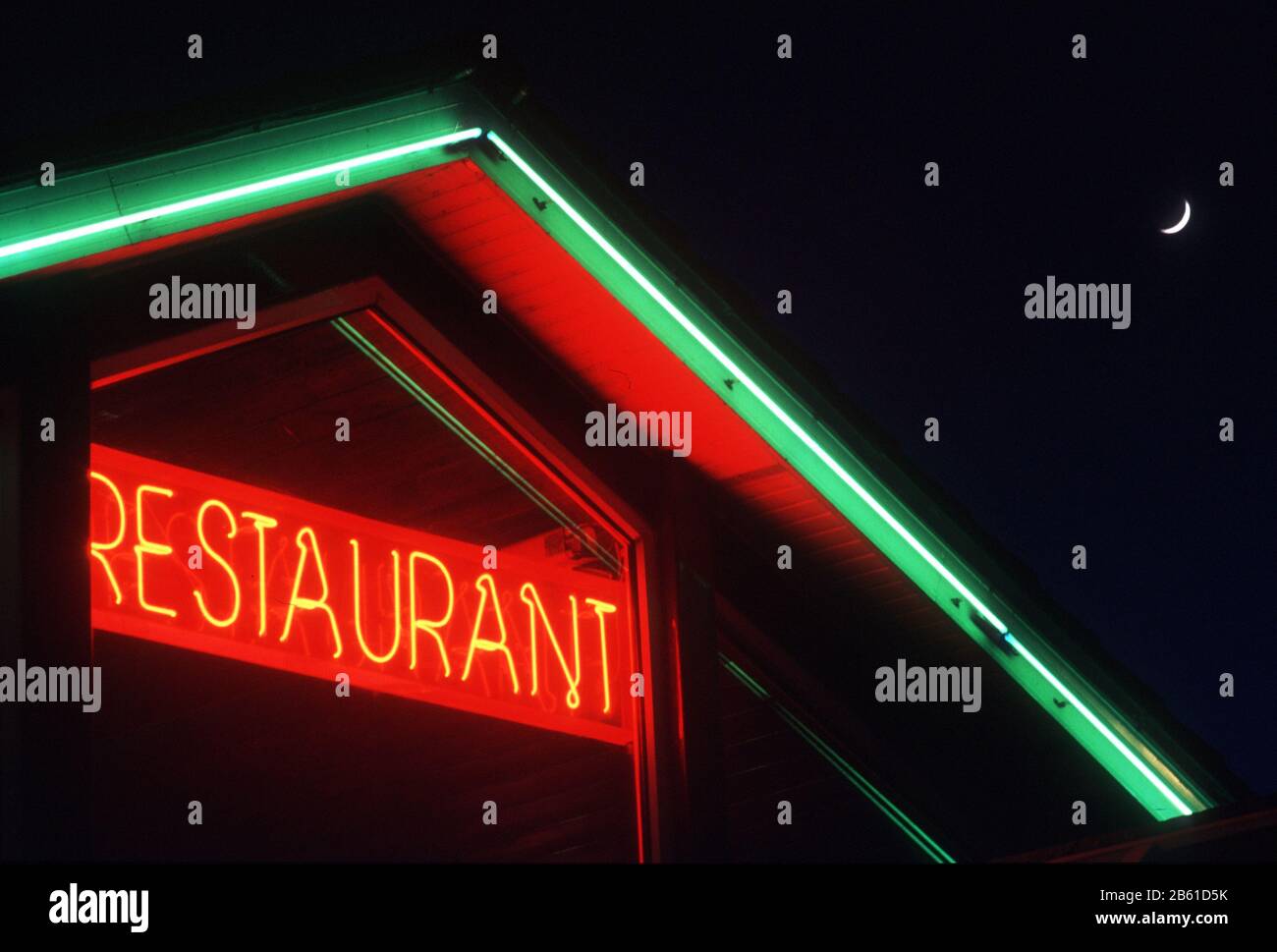 Insegne al neon e illuminazione notturna in un ristorante a Mullingar, in Irlanda, con la luna crescente in alto Foto Stock