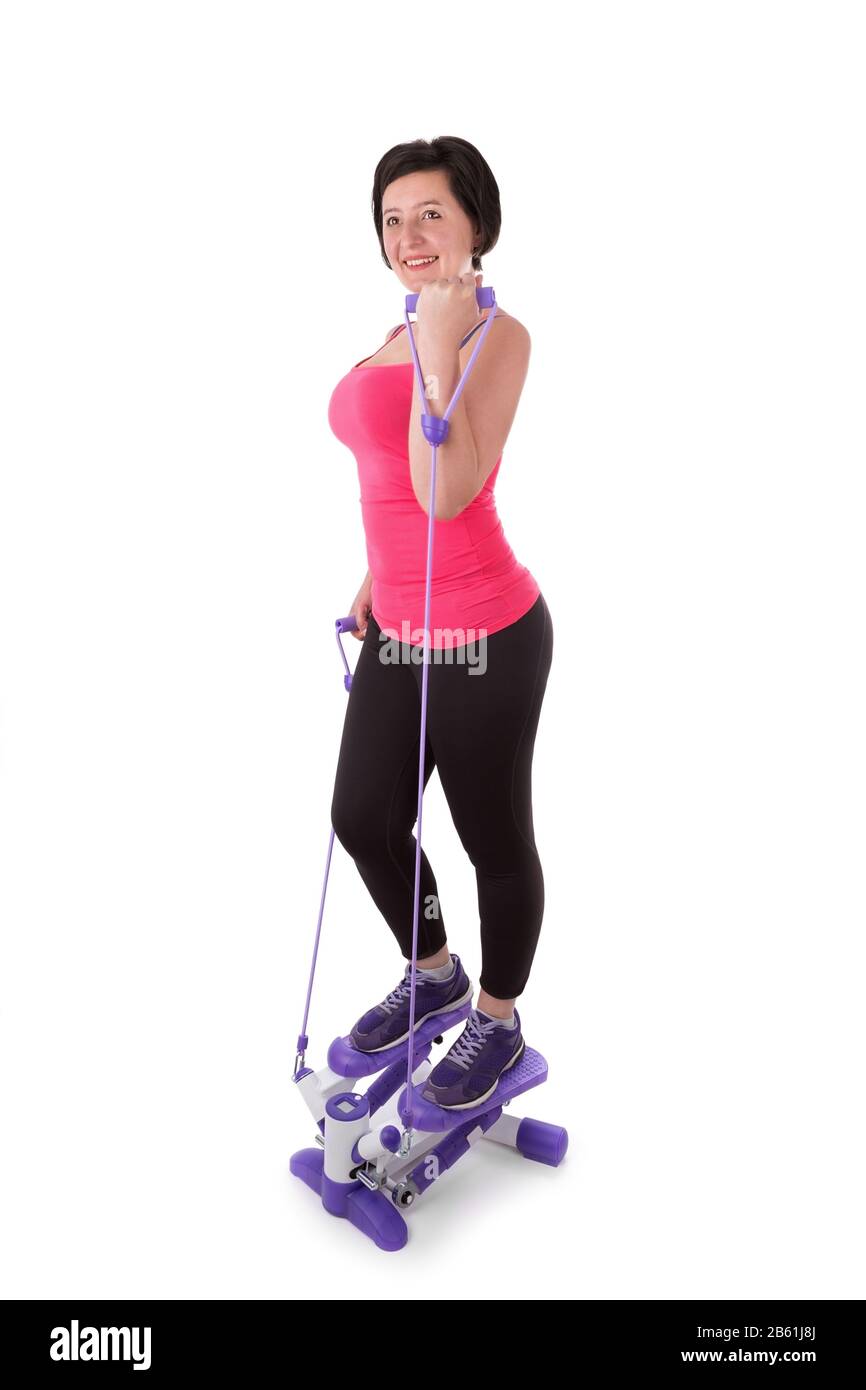 Donna di mezza età su uno stepper con espansori. Impegnati nel fitness. Foto Stock