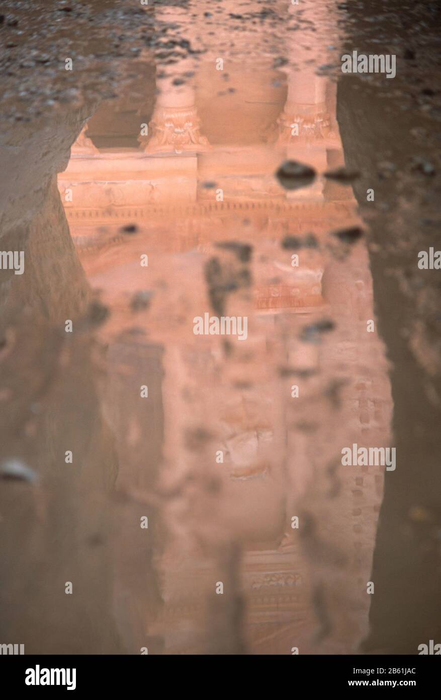 Il Tesoro (al-Khazneh), Petra, Giordania riflesse dall'acqua sul pavimento del Siq. Petra è un sito patrimonio dell'umanità dell'UNESCO. Foto Stock