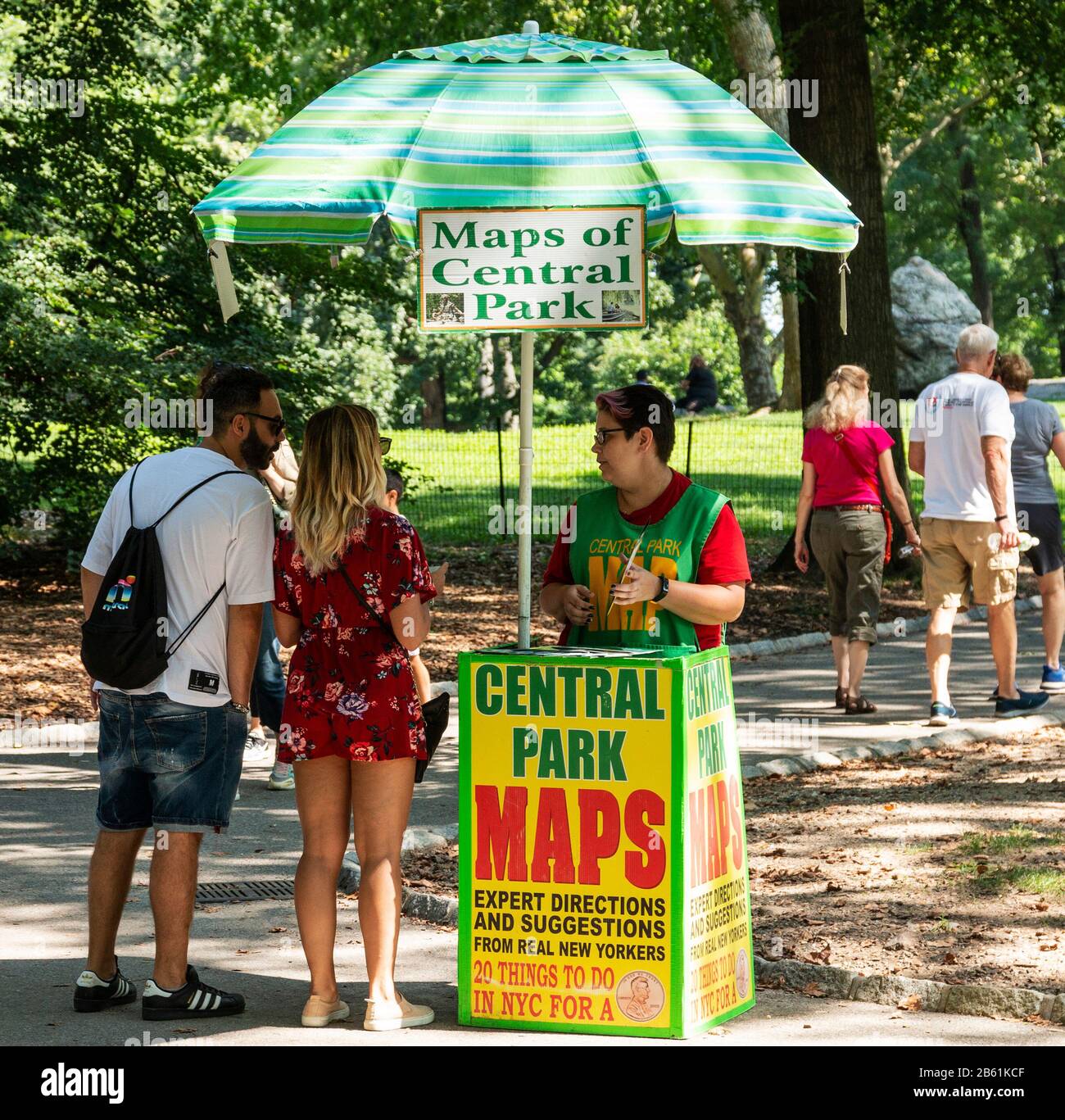 Central Park, New York, Stati Uniti - 14 agosto 2018: Il turista ha posto domande a una donna che vende mappe del parco centrale nel pomeriggio estivo. Foto Stock