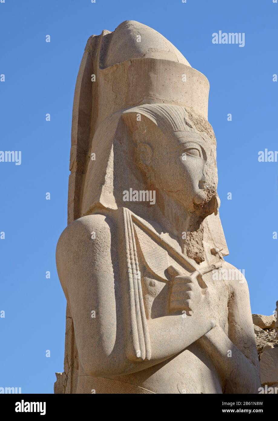 La statua di Ramses II si chiude sullo sfondo blu del cielo. Luogo - Karnak complesso a Luxor (Egitto). Monumenti di grandezza antica. Foto Stock
