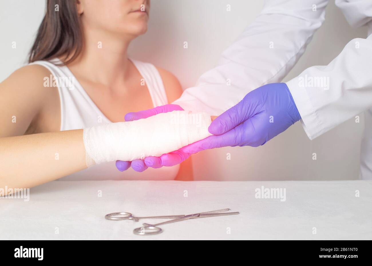Un medico chirurgo esamina il palmo di un paziente per una frattura o una spaccatura in un osso. Frattura dello scapoide, medica Foto Stock