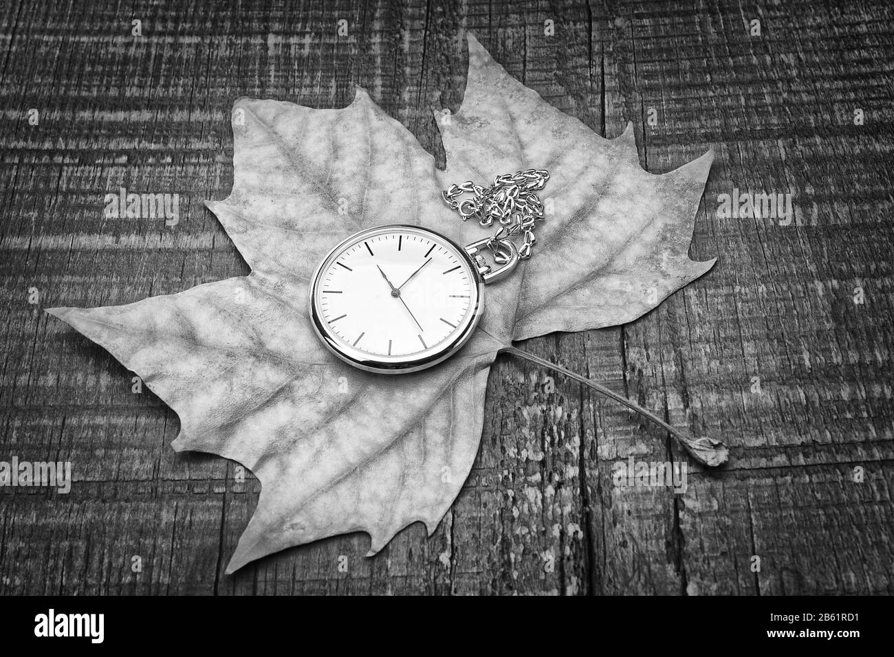 Orologio tascabile vecchio sulla foglia d'autunno. Il simbolo della nostalgia. Foto Stock