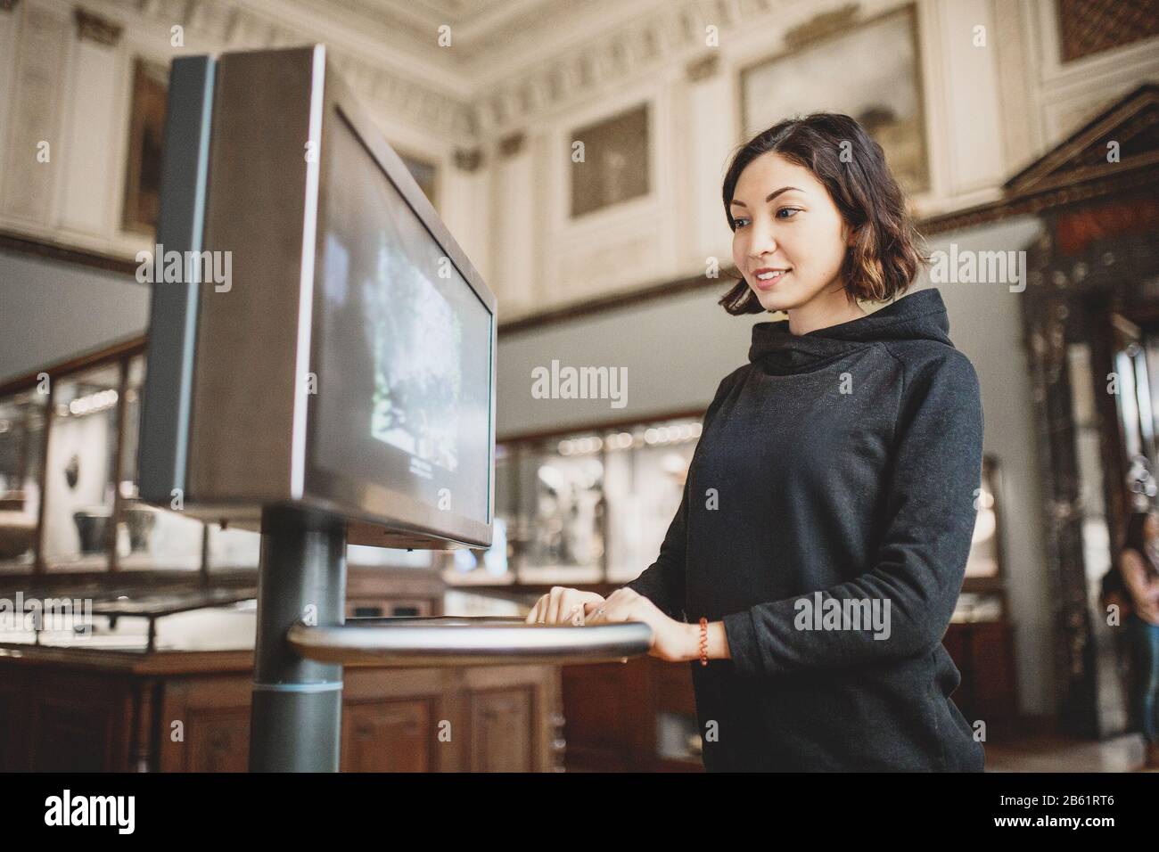 Donna utilizzare monitor interattivo moderno in museo, tecnologie didattiche concetto Foto Stock
