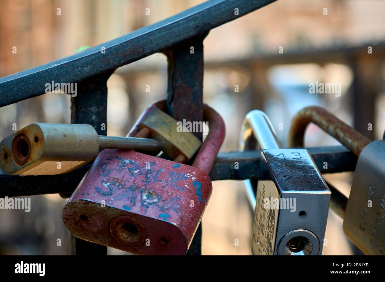particolare di un gruppo di lucchetti legati sulla ringhiera di un ponte che simboleggia l'amore eterno delle coppie Foto Stock