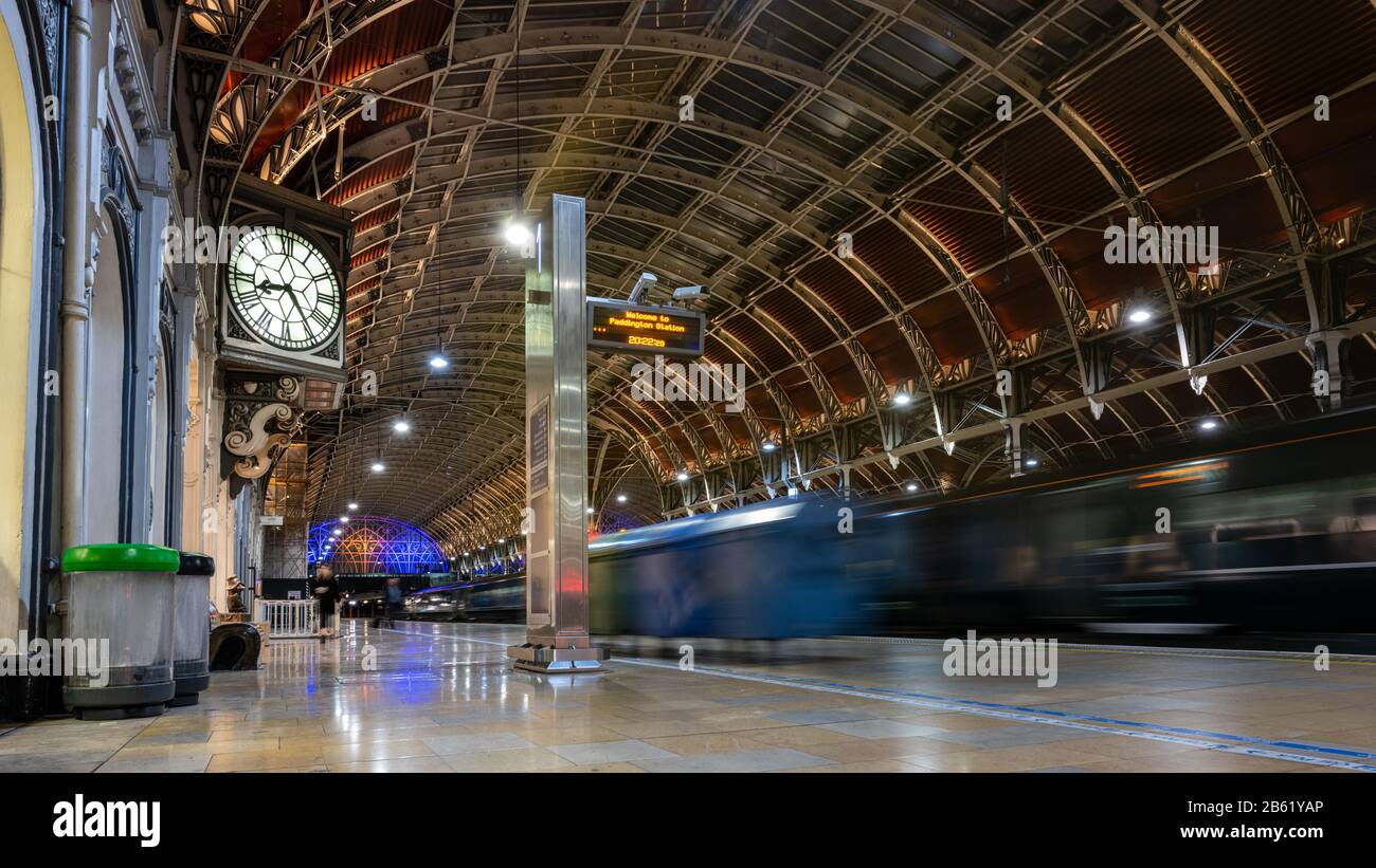 Londra, Inghilterra, Regno Unito - 25 febbraio 2020: Un treno ferroviario Great Western parte da Londra sotto il grande tetto dell'arco vittoriano della stazione di Paddington a Nig Foto Stock