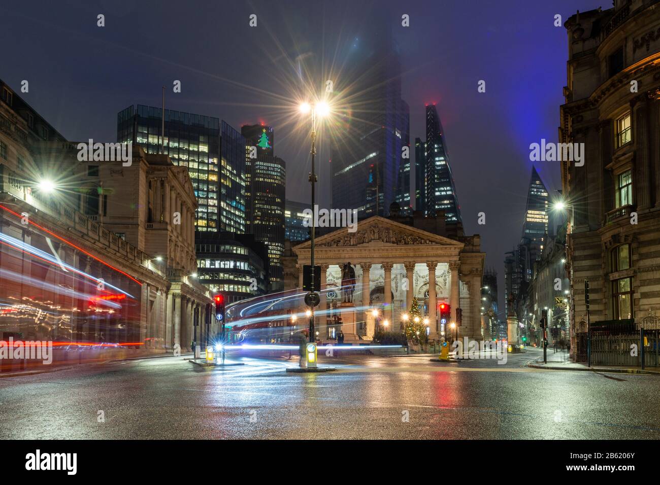 Londra, Inghilterra, Regno Unito - 31 dicembre 2019: Il traffico attraversa lo svincolo notturno della Bank of England, la Royal Exchange e i moderni grattacieli Foto Stock