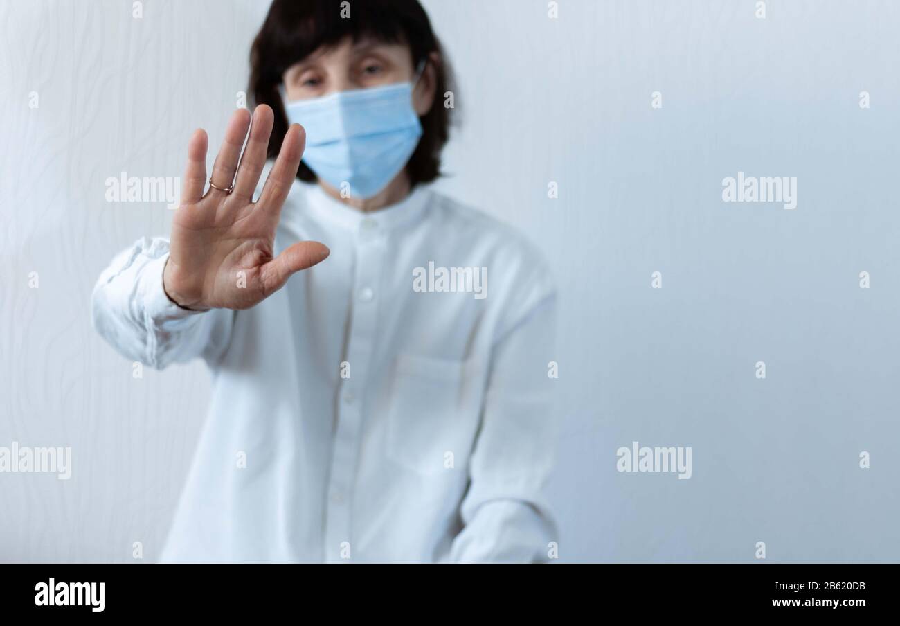 Quarantena del coronavirus e inquinamento atmosferico pm2.5 concetto. Vecchia donna malata che indossa maschera respiratore blu per proteggere con braccio allungato. Wuhan, Cina ep Foto Stock