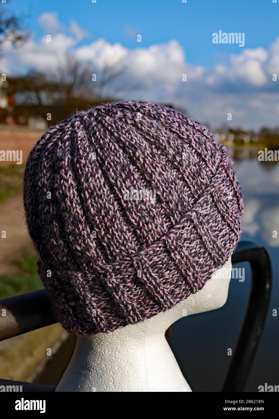 Un cappello lavorato a coste per adulti lavorato a mano in pura lana inglese  in tonalità twedy di porpora e rosa Foto stock - Alamy