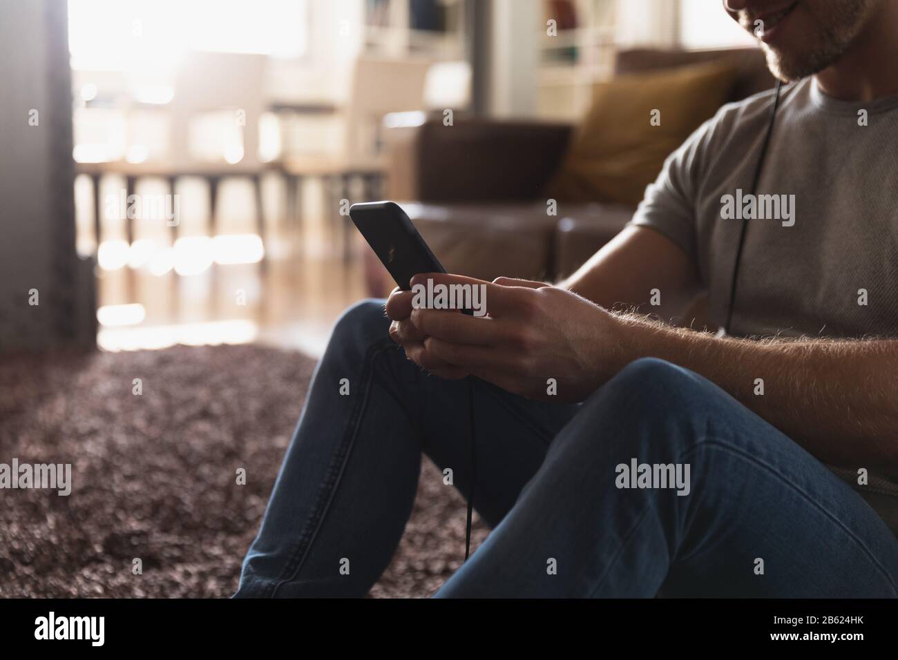 Uomo caucasico che indossa le cuffie e usa il suo telefono Foto Stock