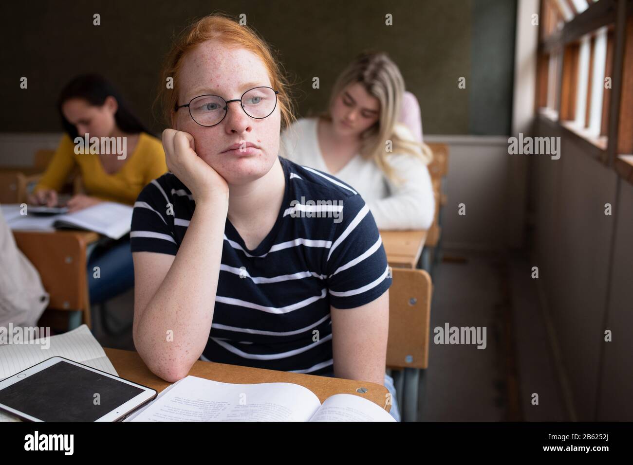 Vista frontale dello studente infastidito in classe Foto Stock