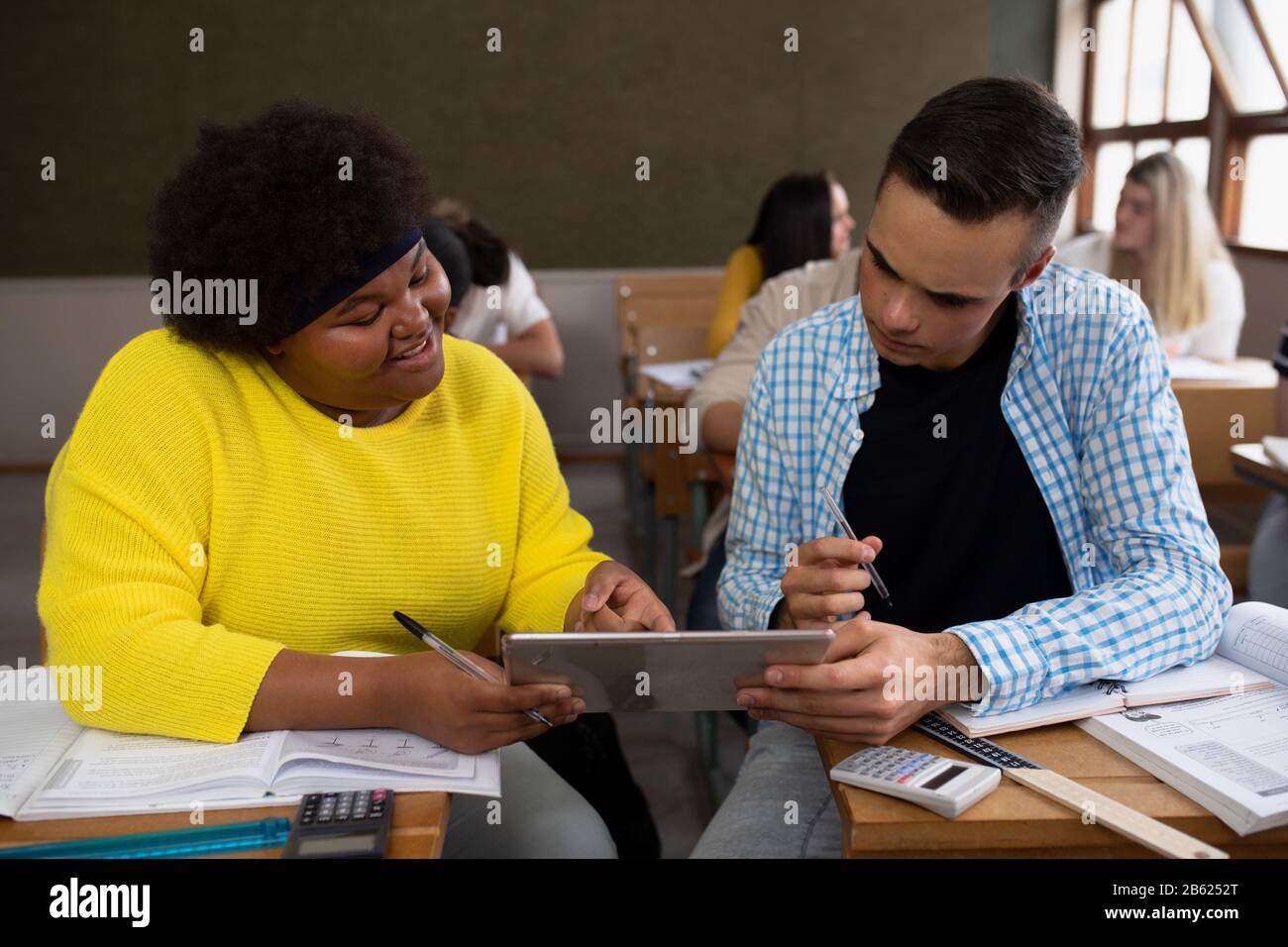 Vista frontale degli studenti che lavorano insieme in classe Foto Stock