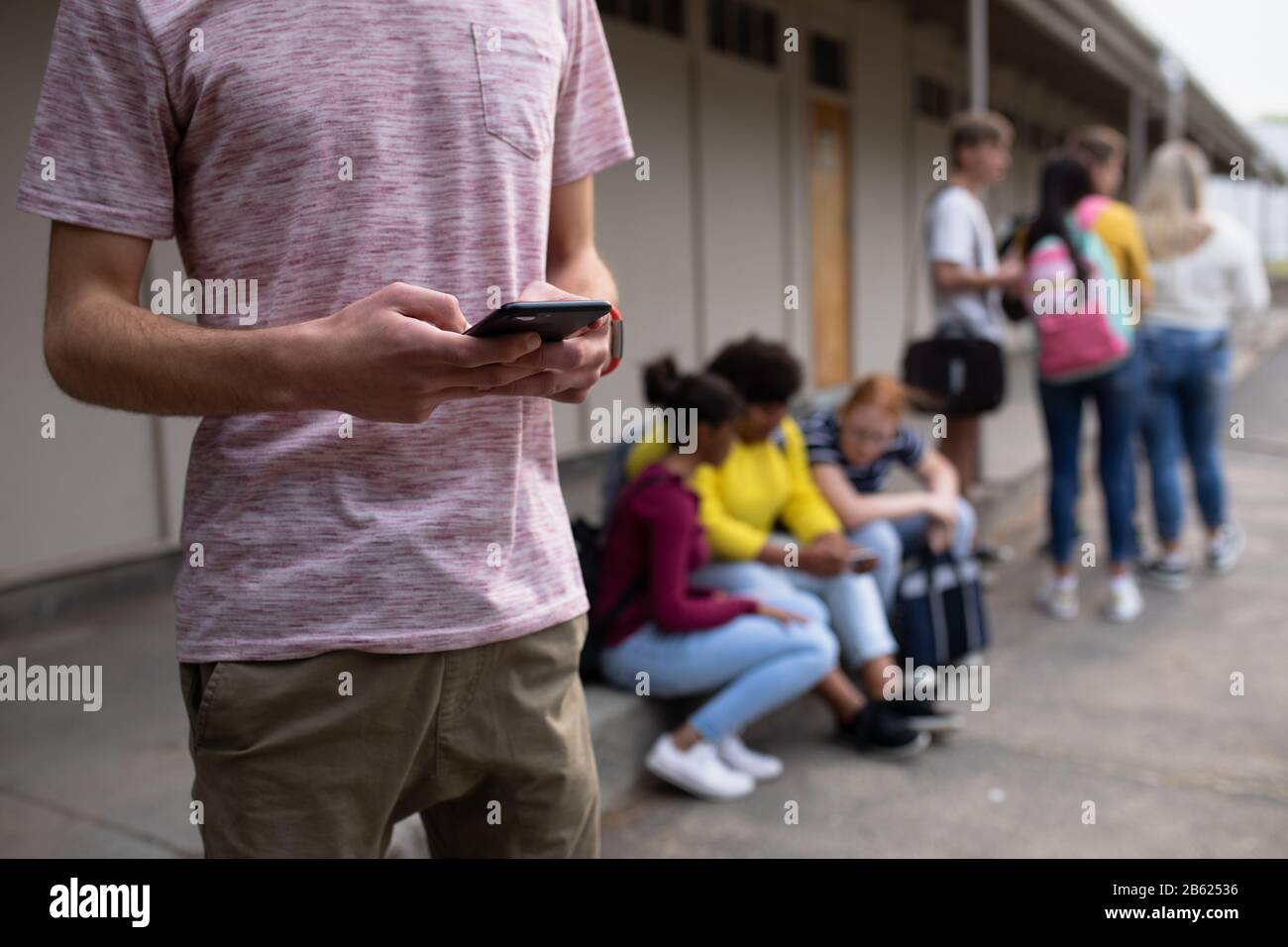 Vista in sezione centrale dello studente sul telefono esterno Foto Stock