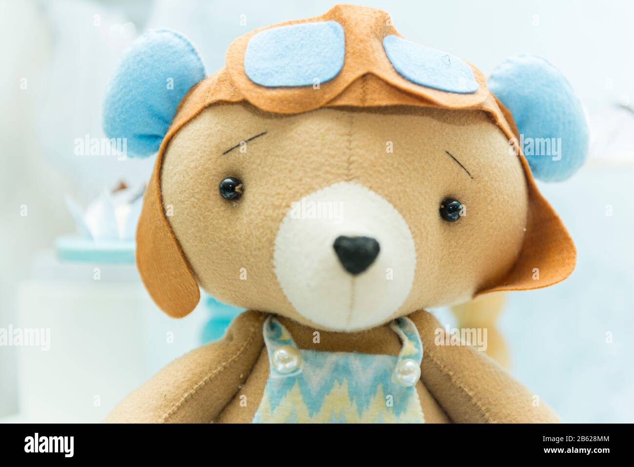 Orsacchiotto con cappello e occhiali da aviatore. Bell'orsetto con occhiali e casco da pilota d'aeroplano d'epoca. Messa a fuoco selettiva. Foto Stock