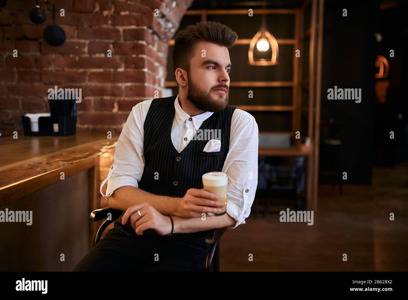 giovane lavoratore pensieroso del casinò che ha un riposo sulla sedia, primo piano vista laterale foto. Foto Stock