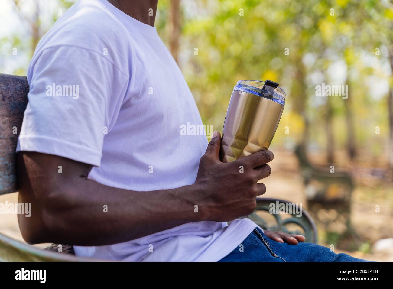 Primo piano di afroamericani che tengono una tazza di bottiglia isolata nel parco. Può essere utilizzato per riciclare, riutilizzare, salvare il concetto di ambiente, con spazio di copia Foto Stock