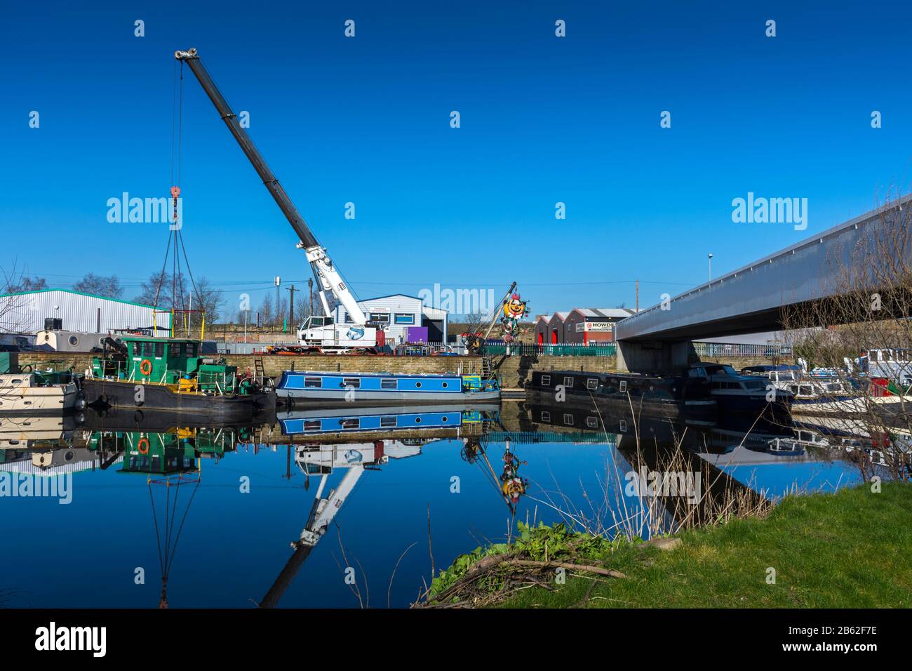 Gru e barche ormeggiate a Wakefield Wharf e Boatyard, sulla Calder & Hebble Navigation, Wakefield, West Yorkshire, Regno Unito. Foto Stock