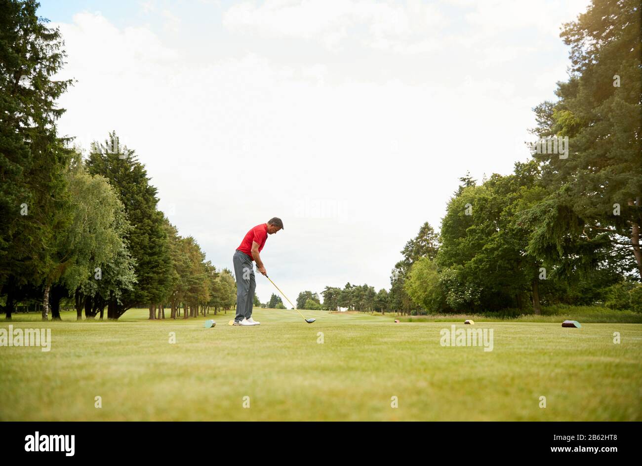 Golfista Maschile Maturo Che Si Prepara A Colpire Tee Shot Lungo Fairway Con Driver Foto Stock