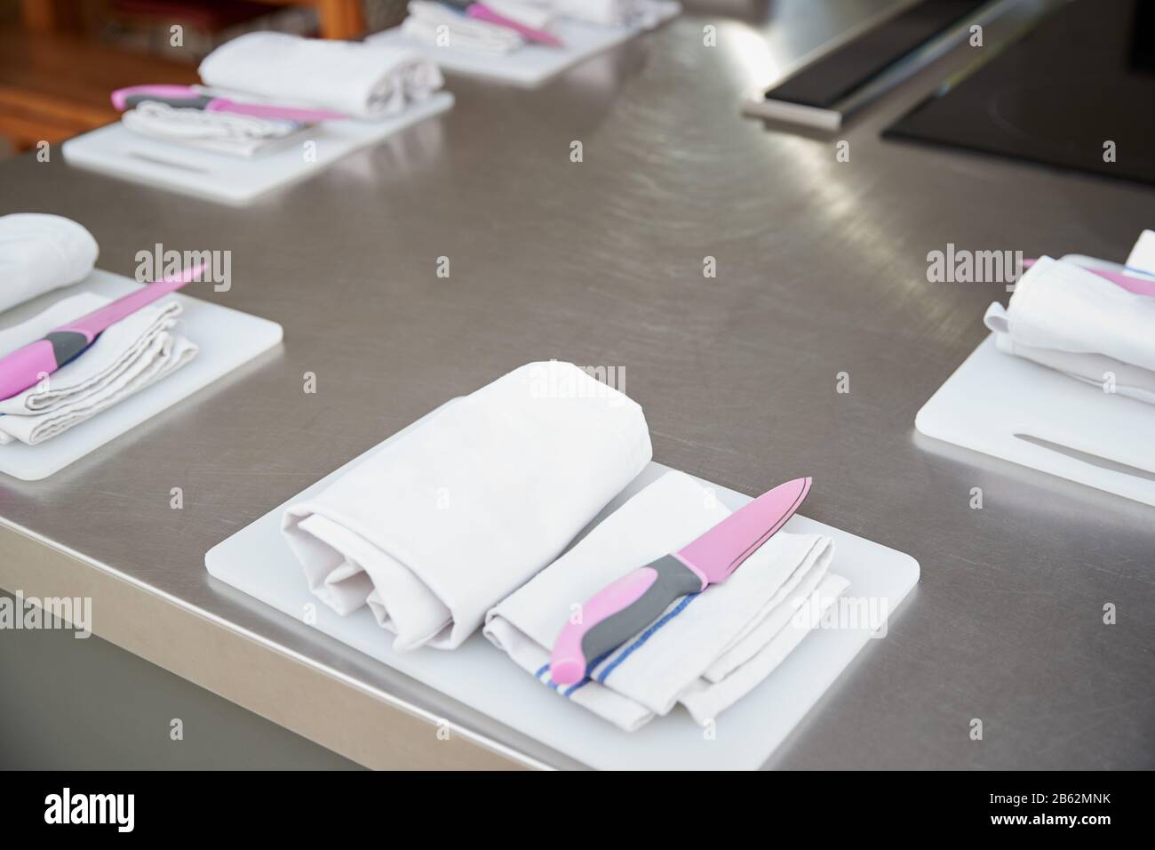 Grembiuli E Coltelli Disposti Su Taglieri In Set Cucina Per Scuola Di Cucina Foto Stock